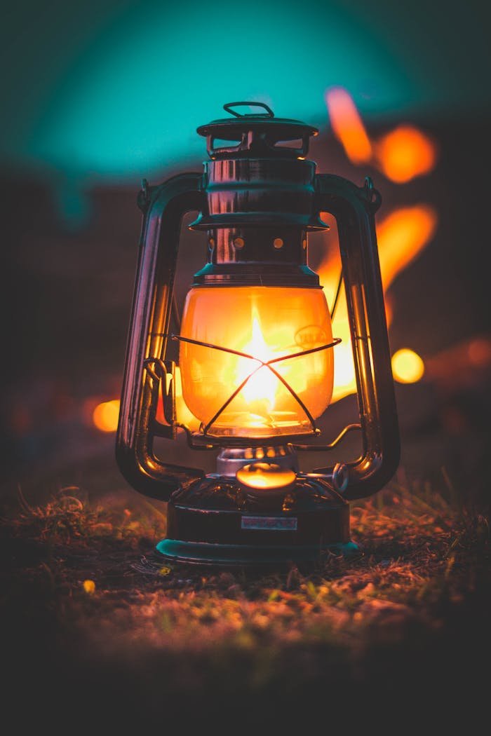 A classic illuminated lantern casting warm glow amidst night setting.